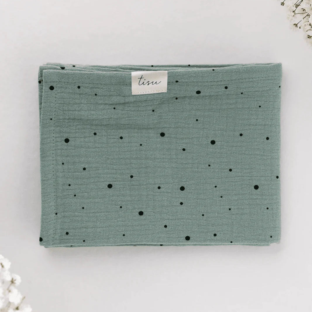 Green fabric with black dots on a white background